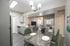 Sophisticated open-plan kitchen and dining area with elegant marble table, stylish seating, and modern lighting, leading to a cozy living space.