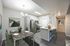 Modern apartment dining and kitchen area featuring elegant furnishings, sleek white cabinetry, and contemporary artwork.