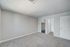 Spacious bedroom with plush carpeting, neutral walls, and access to a walk-in closet and bright bathroom.