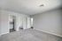 Bright and spacious bedroom with plush carpet and in-unit laundry for modern convenience.