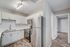 Modern kitchen with sleek stainless steel appliances, white cabinetry, and elegant wood flooring.