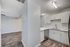 Modern kitchen featuring sleek white cabinetry, stylish backsplash, and stainless steel appliances with elegant wood flooring.