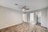 Modern apartment room featuring elegant hardwood floors, a sleek ceiling fan, and convenient access to a bathroom and laundry area.