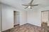 Bright and modern bedroom featuring sleek wood flooring, a spacious closet, and a ceiling fan for comfort.