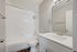 Bright and modern bathroom with elegant fixtures, featuring a pristine bathtub and sleek vanity.