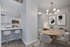 Modern apartment kitchen and dining area with sleek white cabinets, stainless steel appliances, bar stools, and stylish chandelier.
