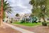 Inviting apartment complex with charming Spanish-style roofs, lush greenery, and a modern playground for family enjoyment.