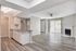 Spacious open-concept living area with modern kitchen, natural light, and chic fireplace.