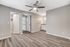 Modern bedroom with sleek hardwood flooring, ceiling fan, and stylish vanity area, perfect for comfort and relaxation.