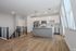 Bright and modern kitchen with sleek white cabinetry, stainless steel appliances, and elegant pendant lighting, showcasing a chic open-plan design with stylish wooden flooring.