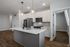 Modern kitchen with sleek white cabinetry, stainless steel appliances, and elegant pendant lighting over a spacious island.