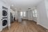 Modern apartment interior with sleek hardwood floors, an open-concept kitchen featuring stainless steel appliances, and in-unit laundry for convenience.