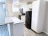 Bright and modern kitchen with sleek black appliances, white cabinetry, and stylish countertops.