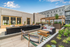 Exclusive amenity deck with stylish seating, modern fire pit, and pergola in upscale apartment complex.