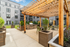 Chic outdoor amenity deck featuring modern pergolas, lush greenery, and professional-grade grilling stations.