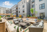 Chic urban amenity deck with stylish outdoor seating, vibrant greenery, and modern apartment backdrop.