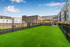 Lush green dog park on exclusive amenity deck with elegant architecture and expansive outdoor space.