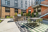 Chic outdoor patio with modern seating, barbecue grill, and lush landscaping.