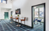 Modern lounge area featuring stylish high-top tables, sleek leather bar stools, and a contemporary wall-mounted fireplace with vibrant flames.