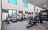 Bright and modern apartment gym with treadmills, exercise bike, and weight equipment, perfect for fitness enthusiasts.