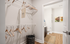 Modern walk-in closet with elegant wooden hangers and a chic wicker basket, leading to a stylish bathroom with contemporary art and a sleek design.