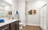 Elegant bathroom with sleek dark wood cabinetry, modern shower enclosure, and vibrant artwork, creating a fresh and inviting atmosphere.