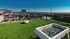 Rooftop lounge at our apartments for rent in Athens, featuring astroturf, a foosball table, and a view of the city of Athens