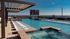 The pool at our student apartments for rent in Athens, featuring beach chairs, sparkling water, and a view of the city.