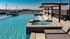 The pool at our student apartments for rent in Athens, featuring beach chairs, sparkling water, and a view of the city.