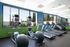 Bright, modern gym with state-of-the-art treadmills and ellipticals, set against vibrant blue and green d&eacute;cor, offering a dynamic workout environment.