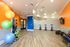 Vibrant fitness studio featuring exercise balls, cycling machines, and modern equipment on sleek hardwood floors.