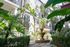 Charming apartment courtyard featuring lush greenery, a beautiful tiered fountain, and modern architecture.
