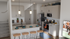 Modern kitchen with elegant pendant lighting, stainless steel appliances, and a cozy breakfast bar with wooden stools. Perfect for entertaining and culinary adventures.