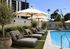 Rendering of a luxurious poolside retreat with plush lounge chairs and vibrant greenery, perfect for relaxation and leisure.