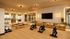 Rendering of a modern apartment gym with sleek design, mirrored walls, exercise bikes, and yoga mats for a dynamic workout experience.
