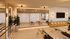 Rendering of a luxurious apartment gym showcasing elegant mirrors, modern lighting, and state-of-the-art pilates equipment in a stylish wooden finish.