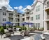 Outdoor lounge at our apartments near Tarrytown, NY, featuring outdoor couches, umbrellas, and a view of the apartments.