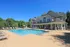 The pool area at our apartments for rent in Marlborough, MA, featuring lounge chairs and a view of the club house.