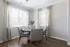 Model dining room at our Marlborough apartments, featuring wood grain floor paneling and a dining table with place settings.