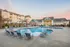 The pool area at our apartments in Charlotte, NC, featuring beach chairs, umbrellas, and a clubhouse.