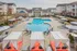 The pool area at our apartments in Charlotte, NC, featuring beach chairs, umbrellas, and covered lounges.