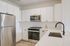 White cabinetry, backsplash, and stainless steel appliances in an Ossining apartment for rent.