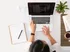 person on laptop with note pad