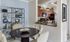 Model living room at our apartments in Mansfield, featuring a dinner table and a bar that opens up into the kitchen.