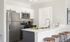 Model kitchen at our apartments in Pembroke, featuring white counters, counter seating, and stainless steel appliances.