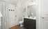 Luxury Pembroke MA apartment bathroom with wood flooring and dark wood cabinetry.
