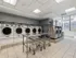 The laundry room at our apartments in Manhattan, New York, featuring washer and dryer machines as well as laundry carts.