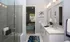 Model bathroom at our apartments in Sandy Springs, featuring tiled floors, white counters, and a shower with glass doors.
