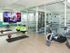 Avia Lowry's fitness center equipped with exercise machines, weights and a television.