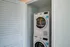 The laundry closet at our of our apartments near Chelsea, features a vertical in-unit washer and dryer and closet door.